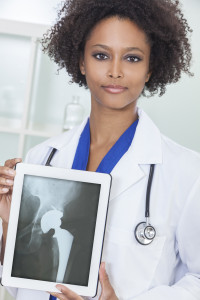 Orthopedic surgeon holding X-ray of artificial hip components