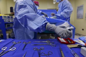 Surgeon implanting surgical mesh to treat hernia 